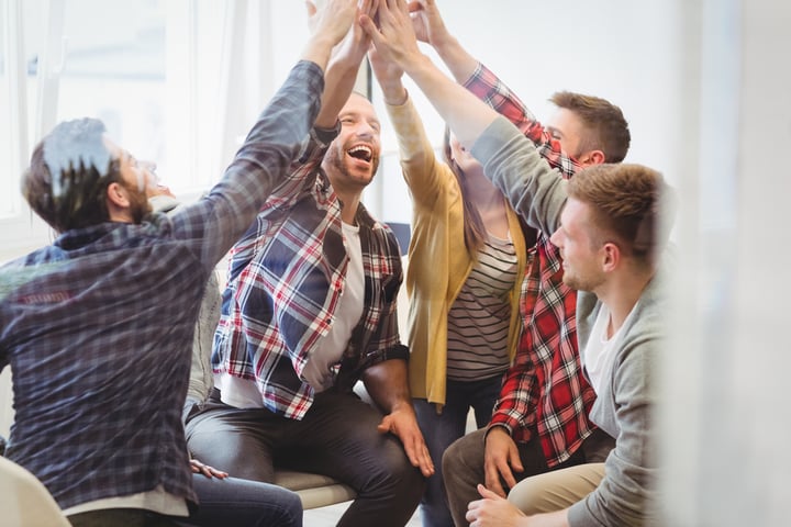 Successful creative business people giving high-five in meeting room at creative office